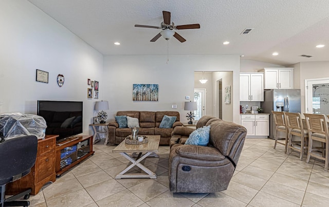 tiled living room featuring ceiling fan, lofted ceiling, and a textured ceiling