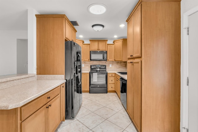 kitchen with tasteful backsplash, black appliances, light tile patterned flooring, light brown cabinetry, and kitchen peninsula