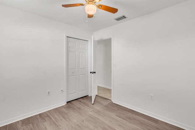 unfurnished bedroom with a closet, ceiling fan, and light wood-type flooring