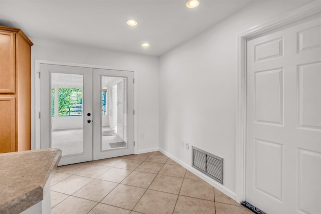 doorway to outside featuring french doors and light tile patterned flooring