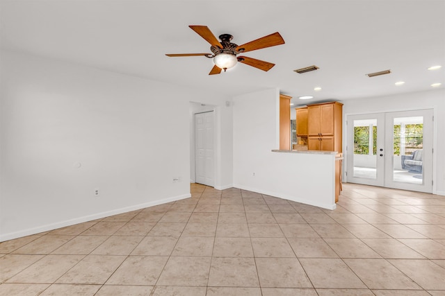 unfurnished living room featuring light tile patterned floors, ceiling fan, and french doors