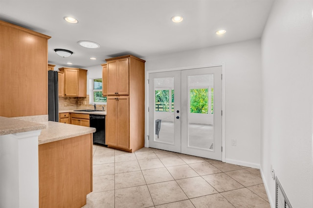 kitchen featuring sink, light tile patterned floors, backsplash, black appliances, and french doors