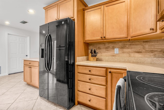 kitchen featuring tasteful backsplash, light tile patterned flooring, electric stove, and black refrigerator with ice dispenser