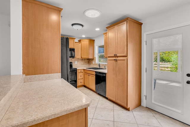 kitchen featuring light tile patterned flooring, tasteful backsplash, sink, black appliances, and light brown cabinets