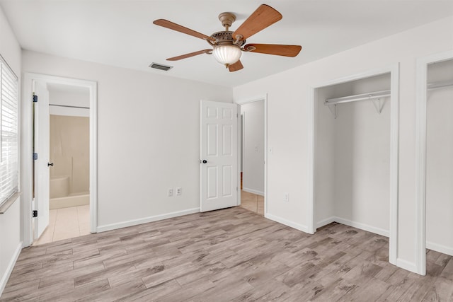 unfurnished bedroom with ceiling fan, ensuite bath, and light wood-type flooring