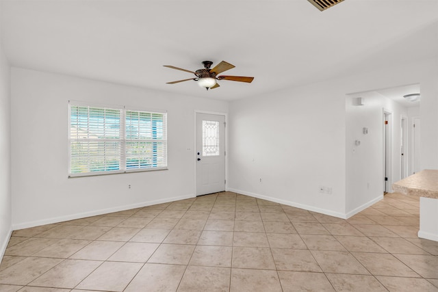 tiled spare room with ceiling fan