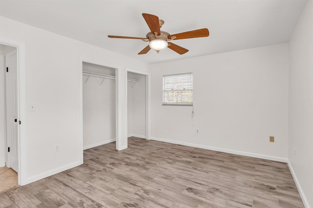 unfurnished bedroom with multiple closets, ceiling fan, and light hardwood / wood-style flooring