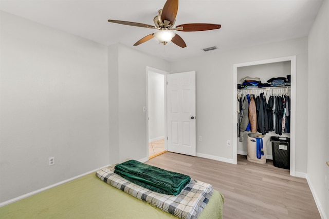 bedroom featuring ceiling fan, a closet, and light hardwood / wood-style flooring