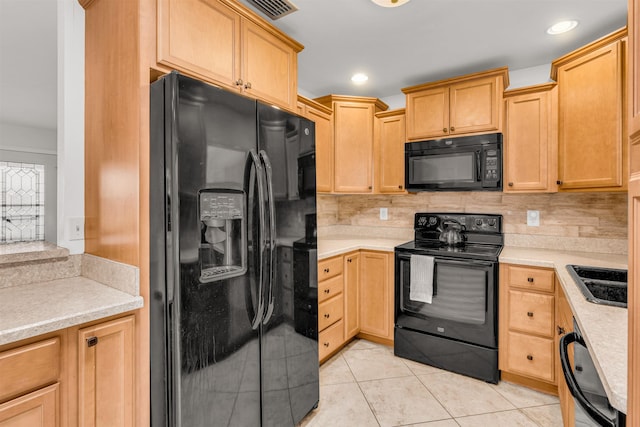 kitchen featuring light tile patterned flooring, light brown cabinetry, sink, black appliances, and backsplash