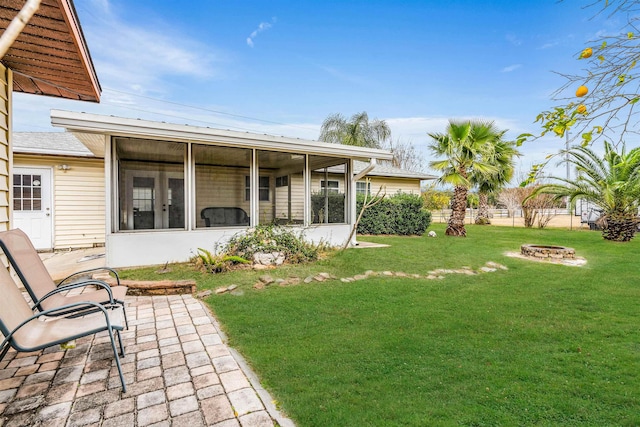 view of yard with a patio, a sunroom, and an outdoor fire pit