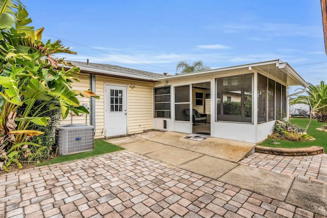 rear view of property featuring central AC, a sunroom, and a patio