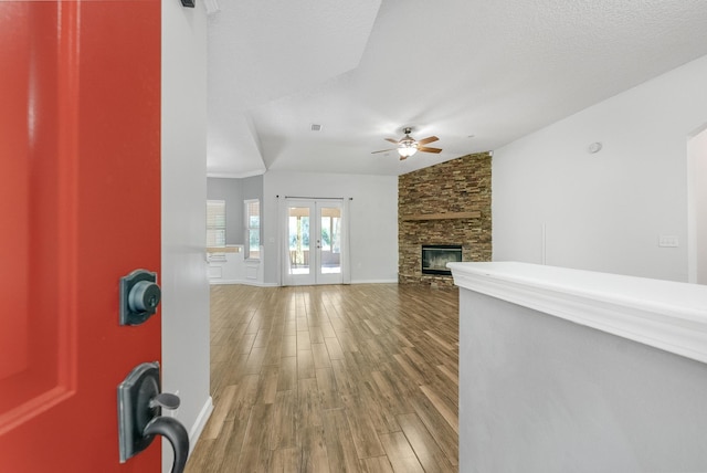 5827 Green Rd, Middleburg, FL 32068 - unfurnished living room featuring wood finished floors, ceiling fan, a stone fireplace, lofted ceiling, and french doors