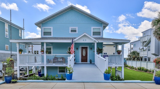 view of front of property featuring covered porch and a front lawn