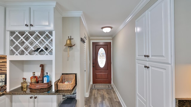 doorway with light wood-type flooring and ornamental molding