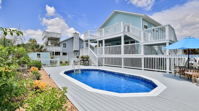 rear view of property featuring a swimming pool side deck