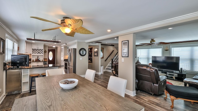 dining space with hardwood / wood-style floors, indoor bar, plenty of natural light, and crown molding