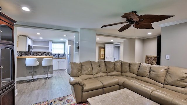 living room with ceiling fan, light hardwood / wood-style floors, and ornamental molding