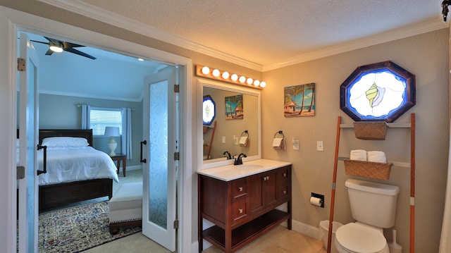 bathroom featuring vanity, crown molding, ceiling fan, toilet, and a textured ceiling