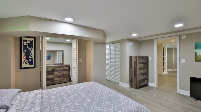 bedroom with light hardwood / wood-style flooring and a closet