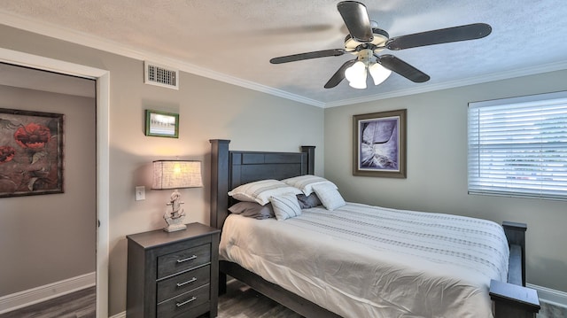 bedroom with a textured ceiling, ceiling fan, crown molding, and dark wood-type flooring