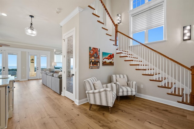 interior space featuring hardwood / wood-style flooring, ornamental molding, a high ceiling, and french doors