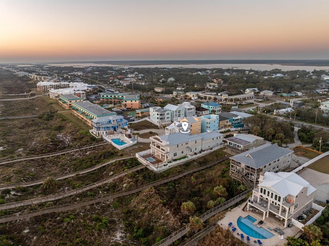 aerial view at dusk featuring a water view