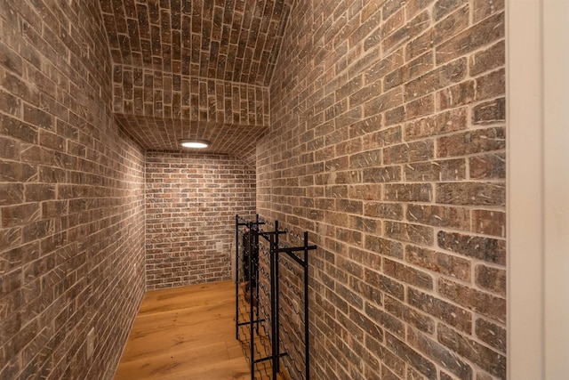 wine area with brick wall and light wood-type flooring