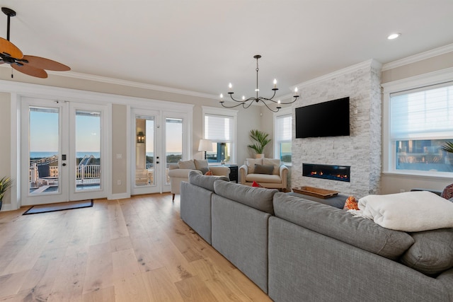 living room with french doors, a fireplace, light hardwood / wood-style floors, and a wealth of natural light