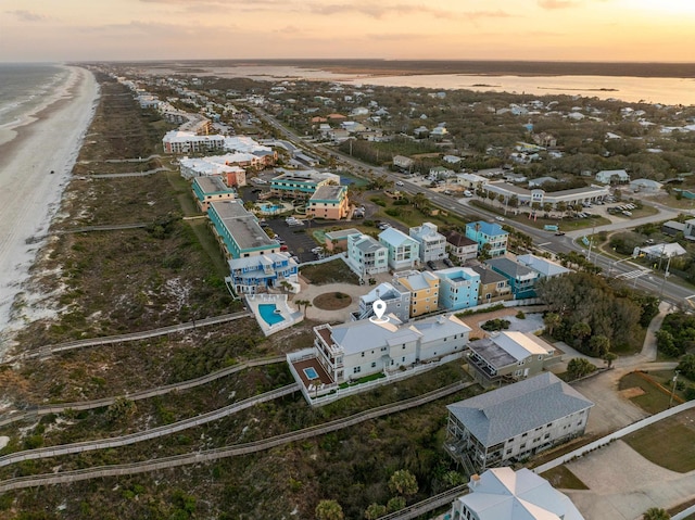 aerial view at dusk featuring a water view