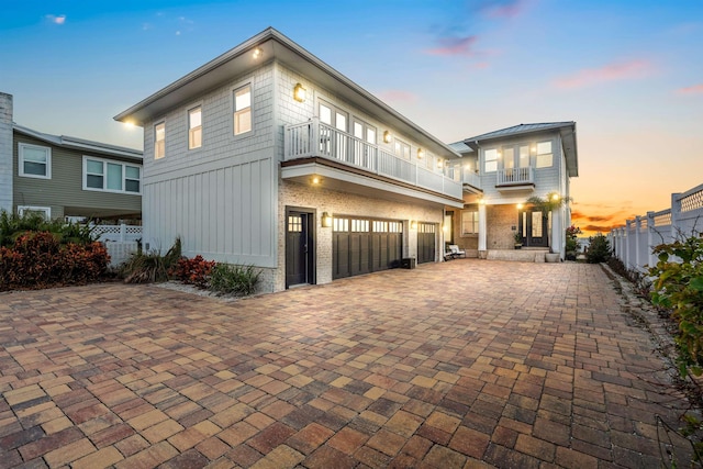 view of front of property featuring a garage and a balcony