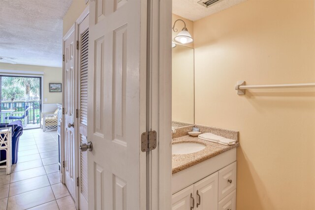 bathroom featuring tile patterned floors, vanity, and a textured ceiling