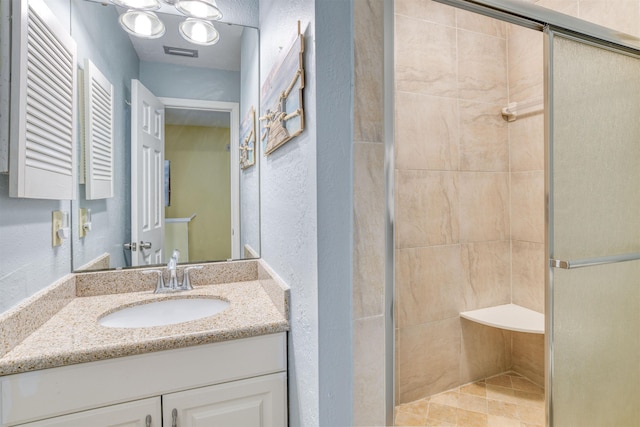 bathroom featuring a shower with door and vanity