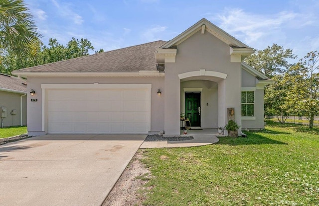 117 Mission Cove Cir, Saint Augustine, FL 32084 - view of front of house featuring an attached garage, stucco siding, driveway, a front lawn, and a shingled roof