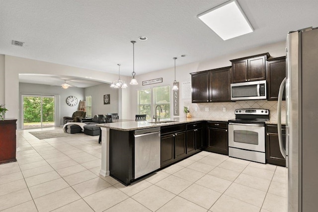117 Mission Cove Cir, Saint Augustine, FL 32084 - kitchen with stainless steel appliances, a sink, open floor plan, a peninsula, and decorative backsplash