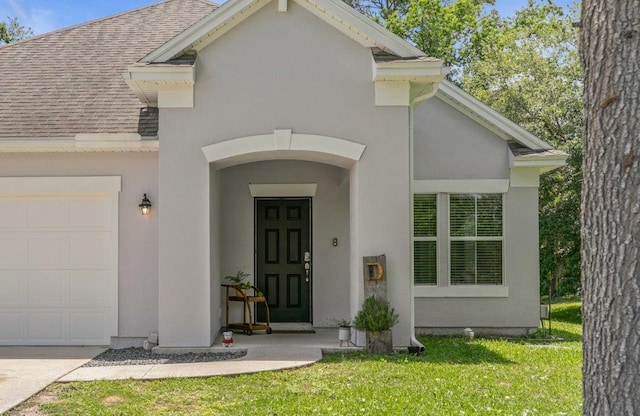 117 Mission Cove Cir, Saint Augustine, FL 32084 - property entrance featuring roof with shingles, an attached garage, a lawn, and stucco siding
