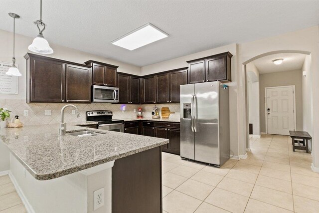 117 Mission Cove Cir, Saint Augustine, FL 32084 - kitchen with stainless steel appliances, a sink, arched walkways, and tasteful backsplash
