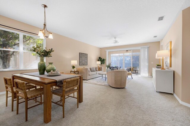 dining area featuring plenty of natural light, ceiling fan, and light carpet