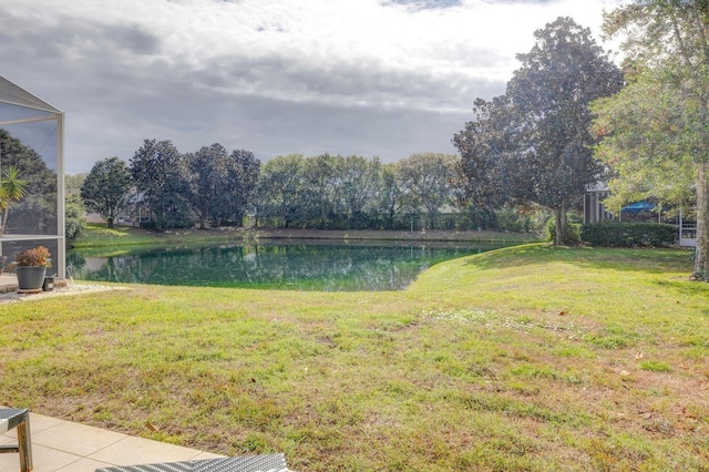 view of yard featuring a water view and glass enclosure