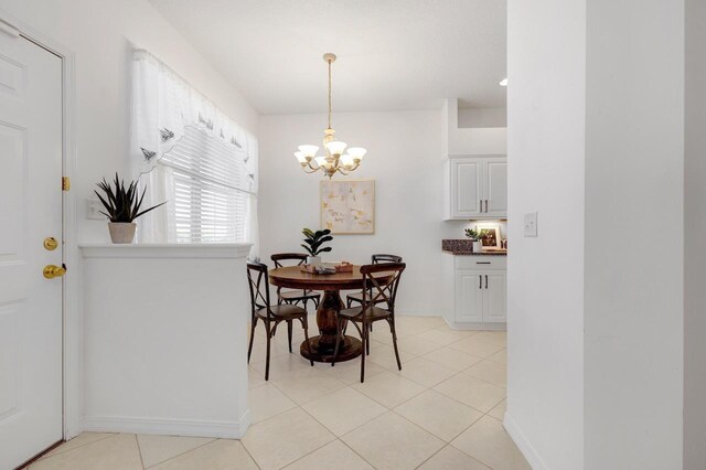 tiled dining space featuring a notable chandelier