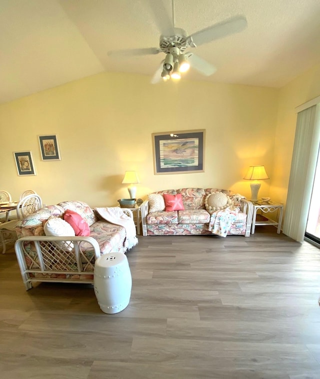 living room with lofted ceiling, ceiling fan, and wood-type flooring