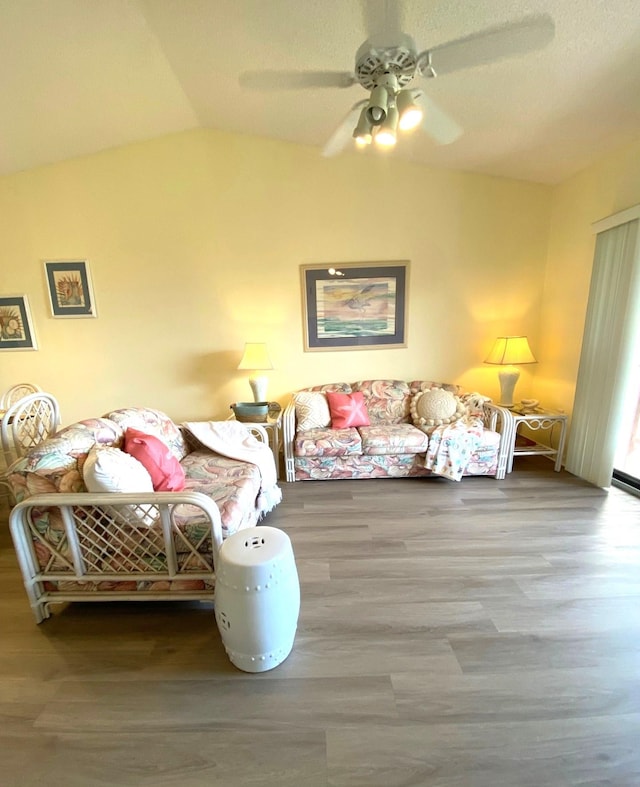 living room with hardwood / wood-style floors, ceiling fan, and lofted ceiling