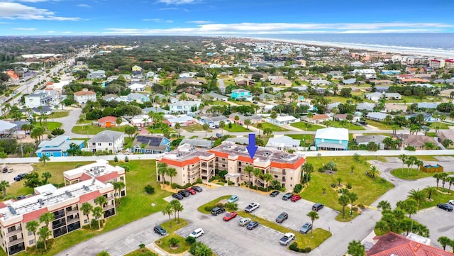 birds eye view of property featuring a water view and a beach view