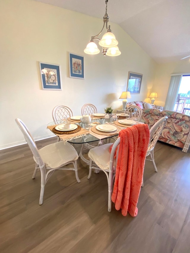 dining room featuring lofted ceiling, dark wood-type flooring, and an inviting chandelier