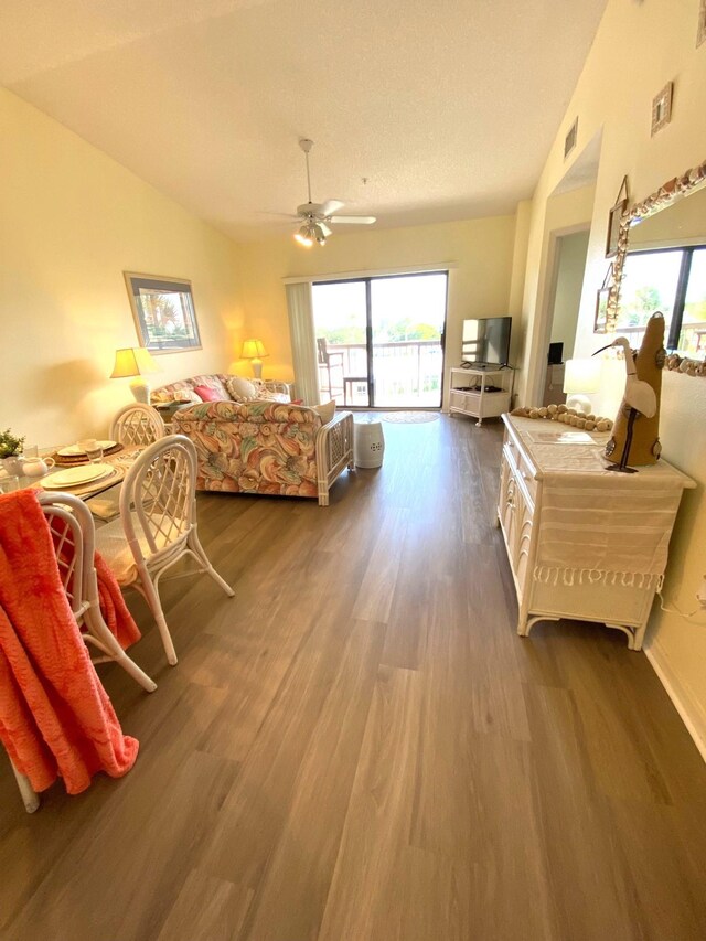 bedroom featuring lofted ceiling, hardwood / wood-style flooring, ceiling fan, access to exterior, and a textured ceiling