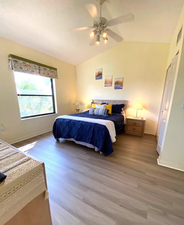 bedroom featuring hardwood / wood-style floors, vaulted ceiling, and ceiling fan