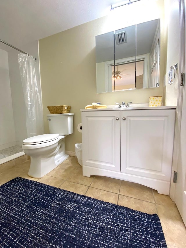 bathroom featuring tile patterned flooring, vanity, curtained shower, and toilet