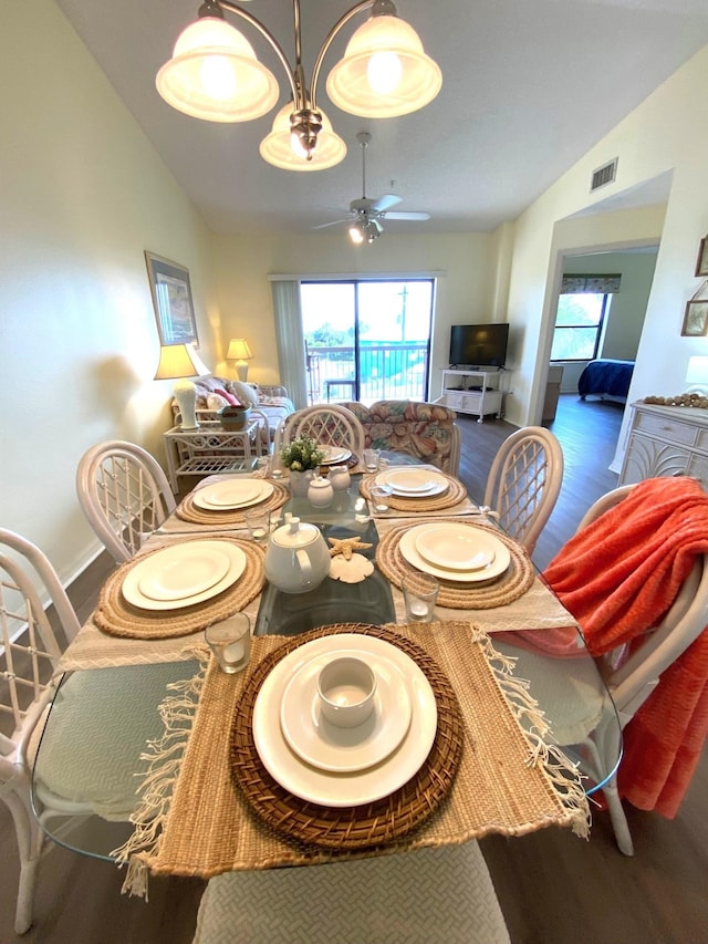 dining space featuring ceiling fan, dark wood-type flooring, and vaulted ceiling