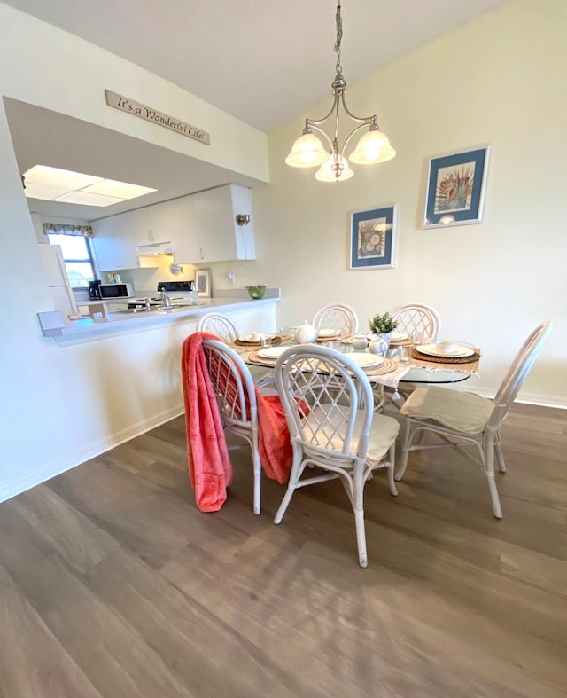 dining area featuring a chandelier and dark wood-type flooring