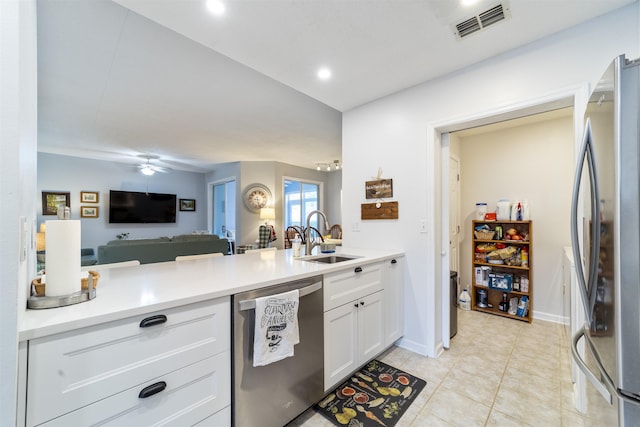 208 Augusta Cir, Saint Augustine, FL 32086 - kitchen with appliances with stainless steel finishes, a peninsula, white cabinetry, open floor plan, and light tile patterned floors