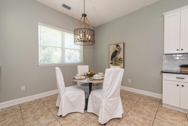 dining room with light tile patterned floors and a notable chandelier